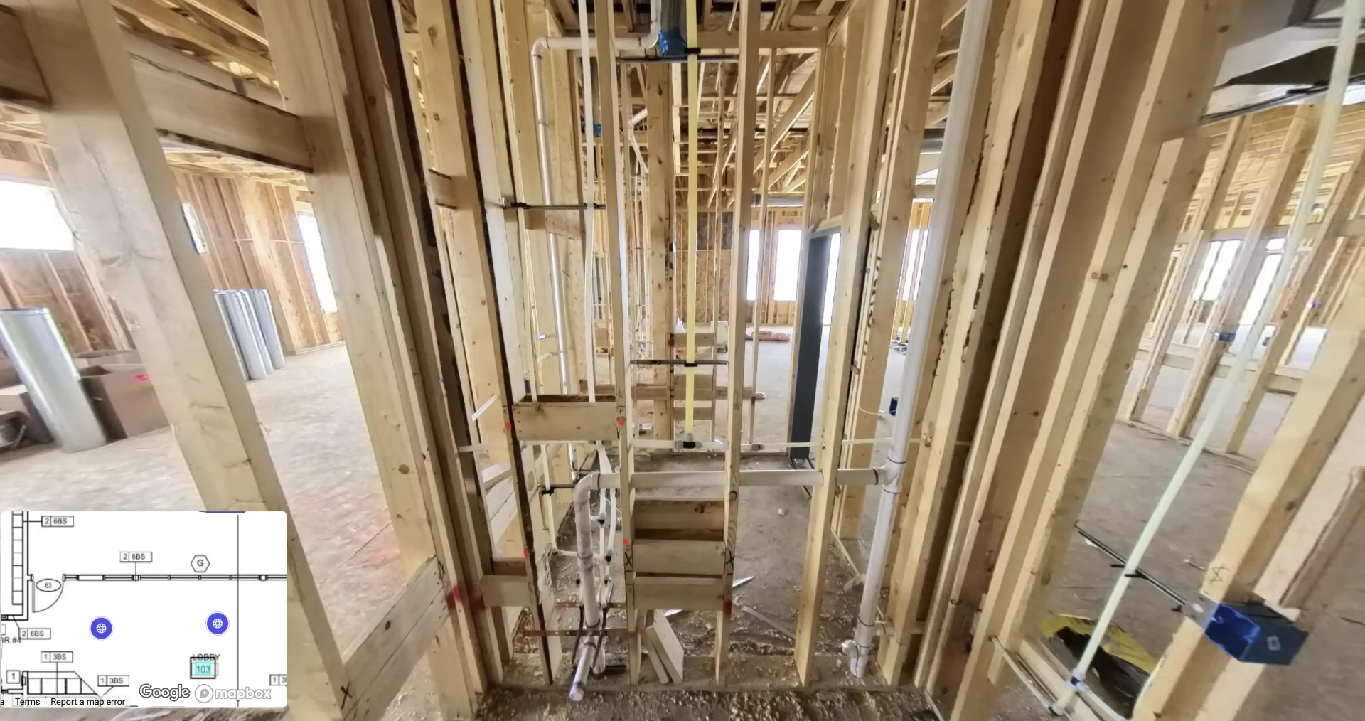 360-degree interior capture of a building under construction showing framed walls, plumbing, and mechanical rough-in before drywall